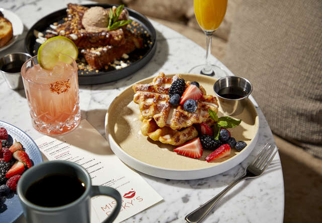 Table filled with colourful breakfast dishes and cocktails at Miss Ricky's.