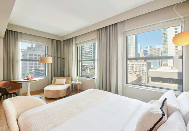 Grand Chamber King room in Virgin Hotels Chicago with a luxurious bed, modern decor, and city views.