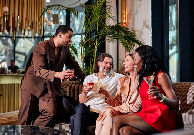 Group of friends enjoying cocktails in Virgin Hotels Dallas.