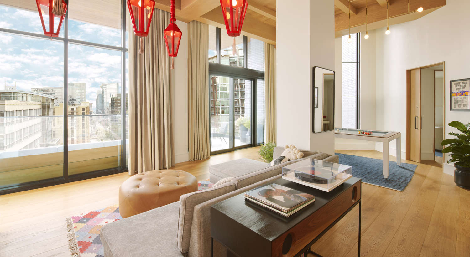 A Virgin Hotels Nashville suite with skyline views and a billiards table