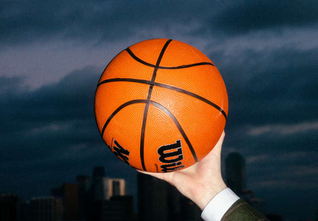 A bright orange Wilson basketball against a dark backdrop.