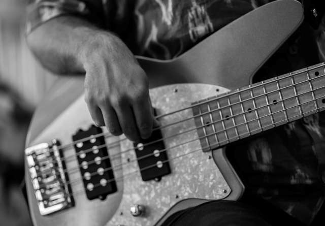 Close up of woman playing the guitar at Virgin Hotels New Orleans.