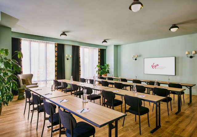 Virgin Hotels’ Sandbox meeting room with modular seating, large windows, and natural light.