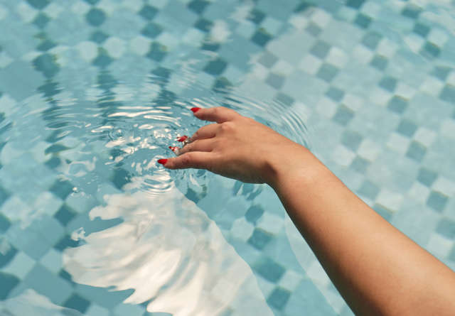 A woman playing in luxurious outdoor pool at Virgin Hotels.