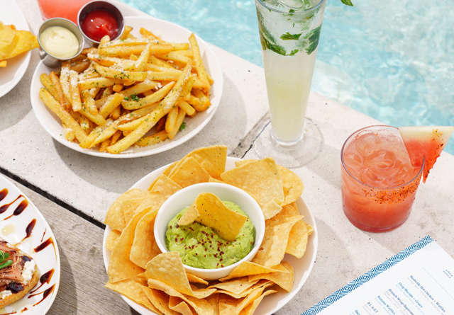 Guest enjoying poolside snacks and cocktails at Virgin Hotels.